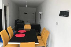 KentにあるThe Dartford Five Bedrooms Attractive Houseのダイニングルーム(黒いテーブル、黄色い椅子付)