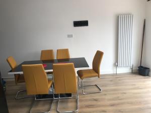 a dining room with a table and yellow chairs at The Dartford Five Bedrooms Attractive House in Kent