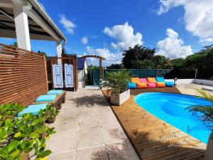patio trasero con piscina y patio en Tropical Dream - Gîte Touristique - 4Adultes et 3Enfants, en Baie-Mahault