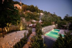 a backyard with a swimming pool and a stone wall at Boutique B&B Mali Pariz in Crikvenica