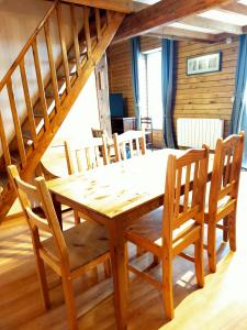 una mesa de madera y sillas en una habitación con escalera en Duplex de 65 m² à l'esprit chalet, en La Bourboule