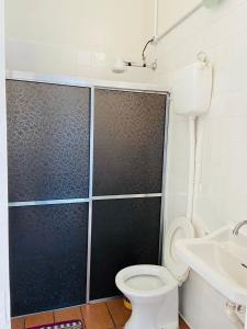 a bathroom with a shower and a toilet and a sink at Hotel Planalto in Poços de Caldas