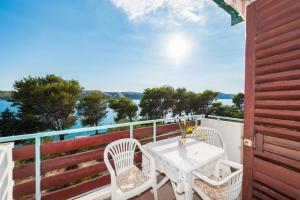 una mesa blanca y sillas en un balcón con vistas en Apartments Jadra - 28 m from beach, en Stara Novalja