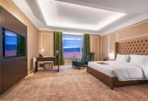 Pokój hotelowy z łóżkiem, biurkiem i telewizorem w obiekcie Suknai Royal Hotel w mieście Ha'il