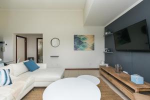 a living room with a white couch and a tv at Modern apartment in a secure golf estate.WIFI in Roodepoort