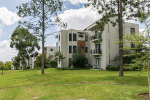 a large white building with trees in front of it at Modern apartment in a secure golf estate.WIFI in Roodepoort