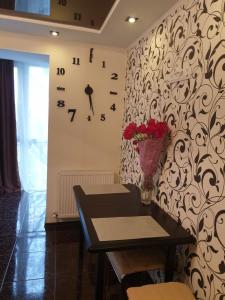 um quarto com uma mesa e um relógio na parede em Elena's Holiday Apartment em Kamianets-Podilskyi
