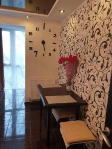 um quarto com uma mesa e um relógio na parede em Elena's Holiday Apartment em Kamianets-Podilskyi