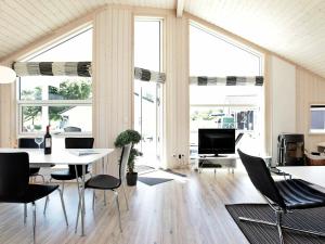 グローセンブローデにある6 person holiday home in Gro enbrodeのテーブルと椅子、窓が備わる客室です。