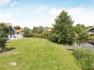 a large yard with a lake and houses at 4 person holiday home in Otterndorf in Otterndorf