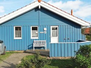 ein blaues Haus mit einer Bank davor in der Unterkunft 4 person holiday home in Otterndorf in Otterndorf