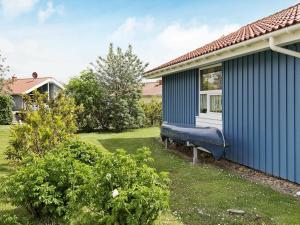 a blue house with a blue couch in the yard at 4 person holiday home in Otterndorf in Otterndorf