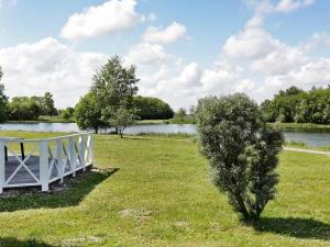 un pont blanc dans un champ à côté d'un lac dans l'établissement 6 person holiday home in Otterndorf, à Otterndorf