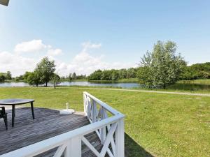 a wooden deck with a table and a grass field at 6 person holiday home in Otterndorf in Otterndorf