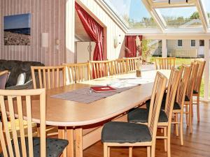 オッテルンドルフにある12 person holiday home in Otterndorfのダイニングルーム(木製テーブル、椅子付)