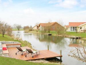 two chairs sitting on a wooden dock on a river at 12 person holiday home in Otterndorf in Otterndorf