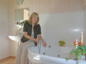 a woman sitting on the edge of a bath tub at 4 person holiday home in Otterndorf in Otterndorf