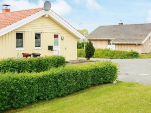 a house with a hedge in front of a house at 6 person holiday home in Gelting in Gelting