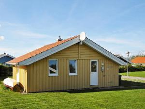 un pequeño cobertizo con una puerta blanca en un campo de césped en 6 person holiday home in Gelting, en Gelting
