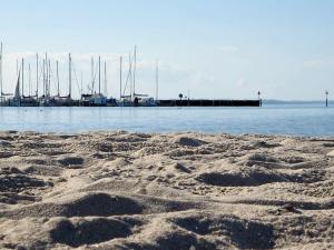 a sandy beach with boats in the water at 6 person holiday home in Gelting in Gelting