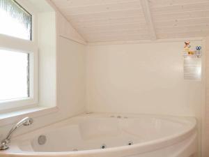 eine weiße Badewanne im Bad mit Fenster in der Unterkunft 6 person holiday home in GROEMITZ in Grömitz