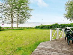 two chairs sitting on a boardwalk near the water at 8 person holiday home in Gelting in Gelting