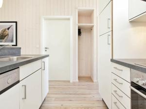 a kitchen with white cabinets and a wooden floor at 8 person holiday home in Gro enbrode in Großenbrode