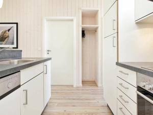 eine Küche mit weißen Schränken und Holzböden in der Unterkunft 8 person holiday home in Gro enbrode in Großenbrode
