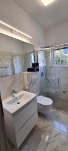 a white bathroom with a sink and a toilet at 2 Bedrooms Apartment Margarita 4+2 in Supetar