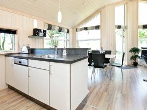 a kitchen with white cabinets and a counter top at Three-Bedroom Holiday home in Großenbrode 8 in Großenbrode