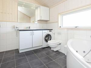 a bathroom with a toilet and a sink and a washing machine at 8 person holiday home in Gro enbrode in Großenbrode
