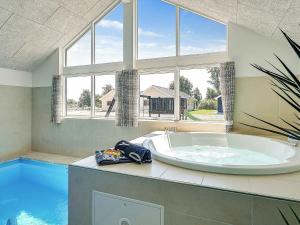 a large bath tub in a room with a pool at 16 person holiday home in Hasselberg in Kappeln