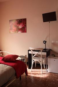 a bedroom with a bed and a desk and a chair at Affittacamere Ciccio e Pinolo in La Spezia