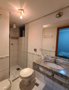 W łazience znajduje się toaleta, umywalka i lustro. w obiekcie Rio Quente Aguas da Serra Apart w mieście Rio Quente