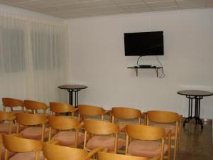 a room with tables and chairs and a flat screen tv at Hotel Villa Naranjos in Jávea