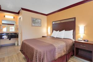 a hotel room with a bed and a bathroom at Americas Deluxe Inn- Marysville in Marysville