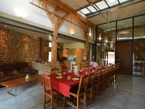 una sala da pranzo con tavolo e sedie rossi di Spacious house in a farm located in the bucolic a Teuven