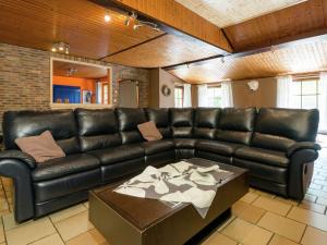 a living room with a leather couch and a table at Modern Holiday Home in Waimes near Lake in Waimes