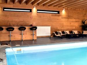 a room with a pool and chairs and a table at Luscious Holiday Home in Waimes with Pool Sauna in Robertville