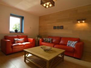 a living room with red couches and a coffee table at Holiday Home in Malmedy with Indoor Heated Pool in Malmedy