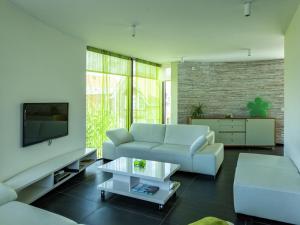 a living room with a couch and a tv at Modern holiday home near Bruges and the North Sea in Dudzele