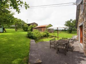 un patio con mesa, sillas y sombrilla en Heritage Holiday Home in Roumont en Roumont