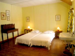 1 dormitorio con cama blanca y lavamanos en The right wing of the castle of Roumont, en Roumont