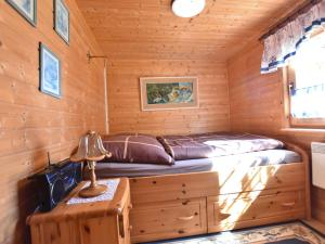 a bed in a wooden cabin with a table and a lamp at Serene Holiday Home in K gsdorf with Sea View in Kägsdorf