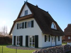 une petite maison blanche avec un toit marron dans l'établissement Fairy tale holiday home in Rerik with private terrace, à Rerik