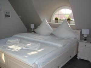 - un lit blanc avec des oreillers blancs et une fenêtre dans l'établissement Fairy tale holiday home in Rerik with private terrace, à Rerik