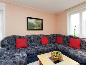 a living room with a black couch and red pillows at Luxury holiday home in Elend with private pool in Elend