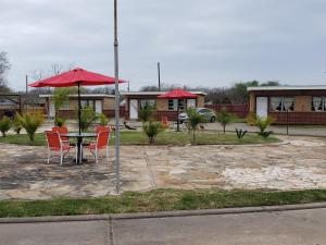 a table with chairs and an umbrella in a courtyard at Gulf Crest Motel in Freeport