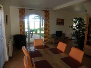 a living room with a dining room table and chairs at Stylish detached villa on a country estate with a pool in Sellerich