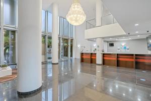 a large lobby with white columns and a chandelier at Tweed Ultima Apartments in Tweed Heads